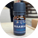 A bottle of LJ Turtle Aromatics Waawaa Northern Lights essential oil blend, featuring a dark blue label with a turtle logo, placed on a wooden surface with a blurred background.