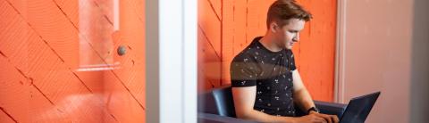 Person working on a laptop in a modern workspace, representing focus and technology for The AI Advantage webinar on career advancement.