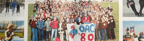 Large group photo of the Ontario Agricultural College Class of 1980 gathered outdoors on a grassy hill, with individuals dressed in retro 1980s clothing and some holding an “OAC ’80” banner.