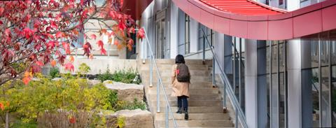 Student walking up stairs outside U of G building
