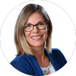 A professional portrait of Katherine Rentsch, BSc. (Eng) '01, a woman with shoulder-length blonde hair, wearing glasses, a blue blazer, and a white blouse with a floral pattern, smiling against a white background.