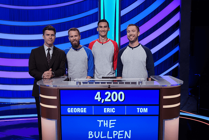 U of G alumni trivia team, called "The Bullpen" stand at podium with tv host, Colin Jost.